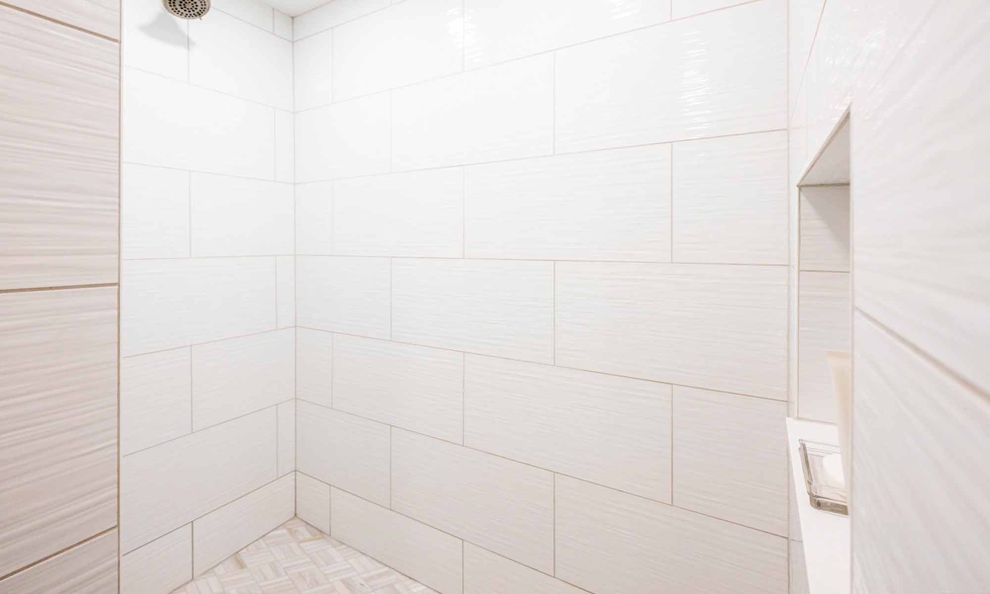 closeup of white shower tile in brick pattern
