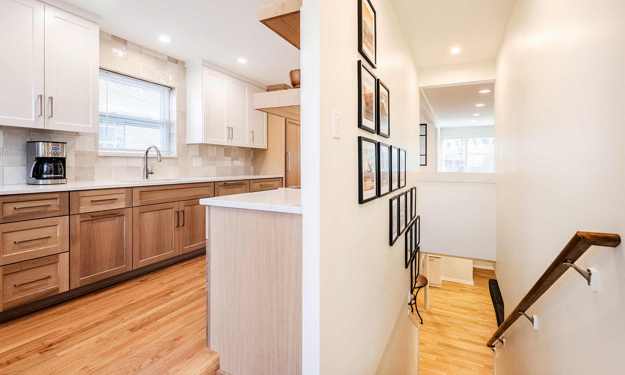 open plan showing stairs to basement adjacent to galley kitchen and looking towards open entry hall