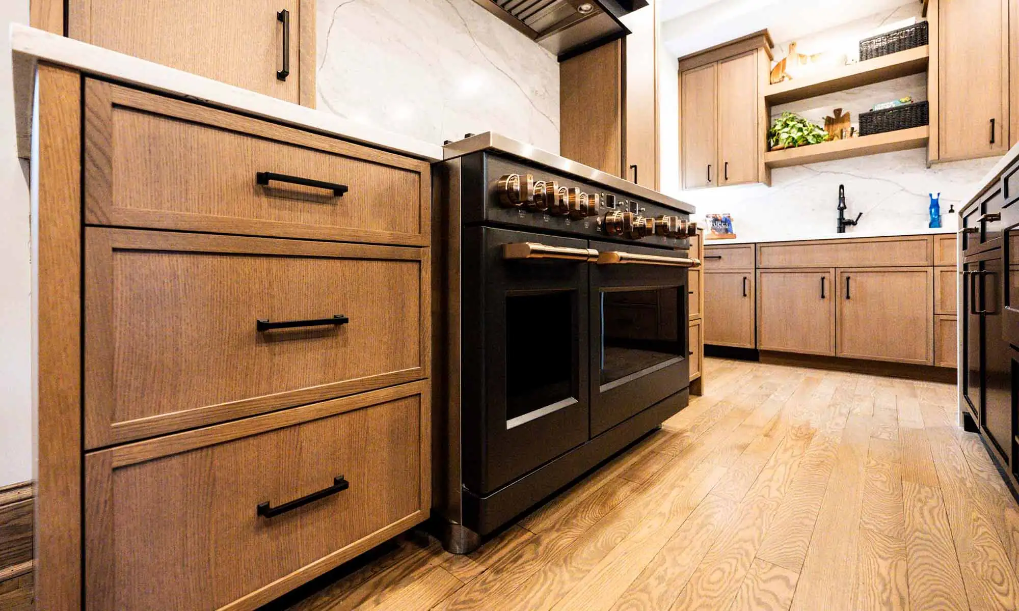 view of luxury kitchen remodel large grey range and white oak cabinetry