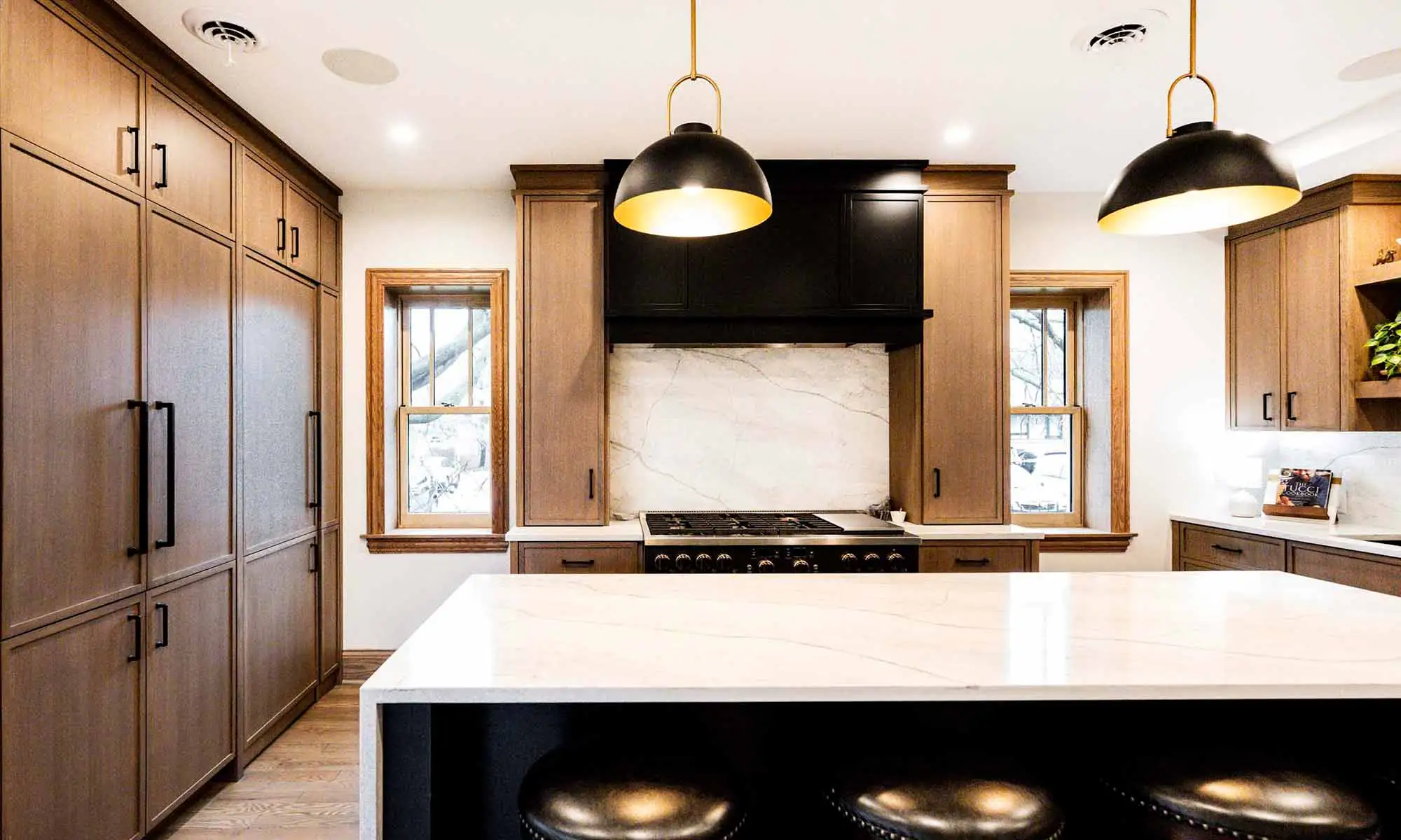 view of luxury kitchen remodel with windows flanking large range wall and white oak cabinetry