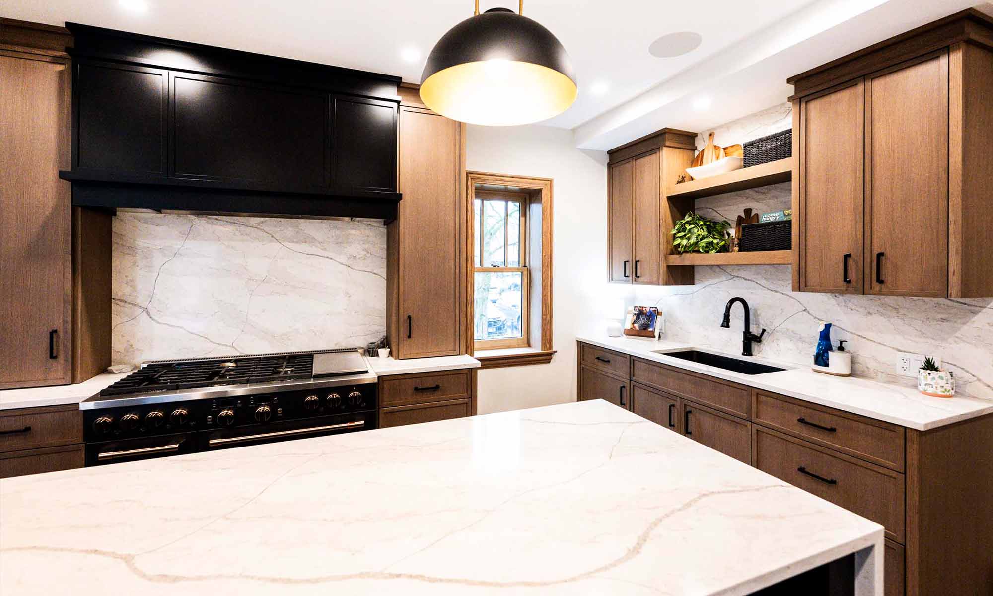 view of luxury kitchen remodel with windows flanking large range wall and white oak cabinetry