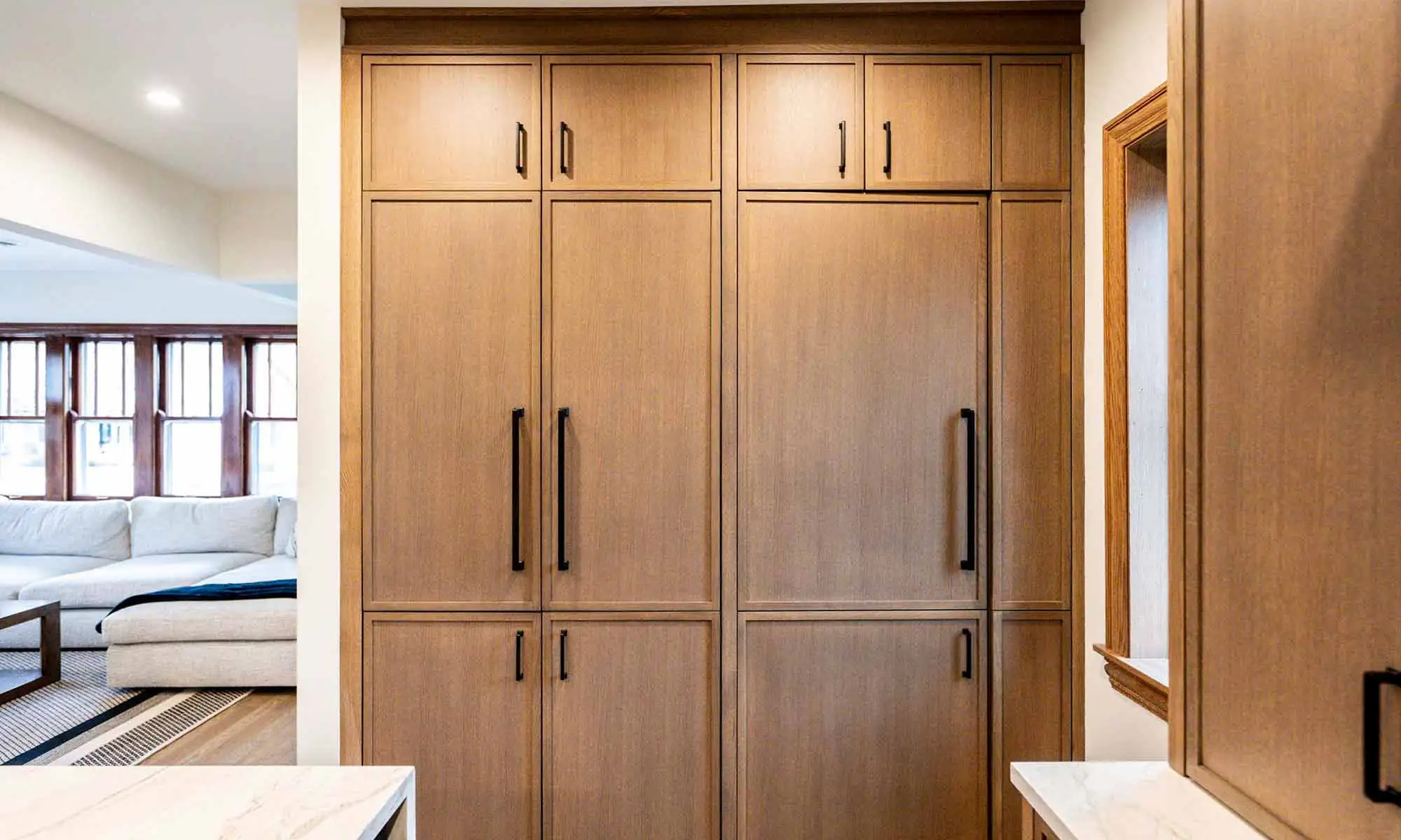 hidden pantry door closed in white oak cabinetry