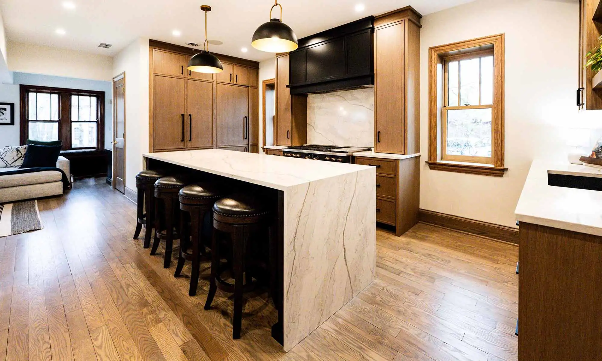 view of luxury kitchen remodel with windows flanking large range wall and white oak cabinetry