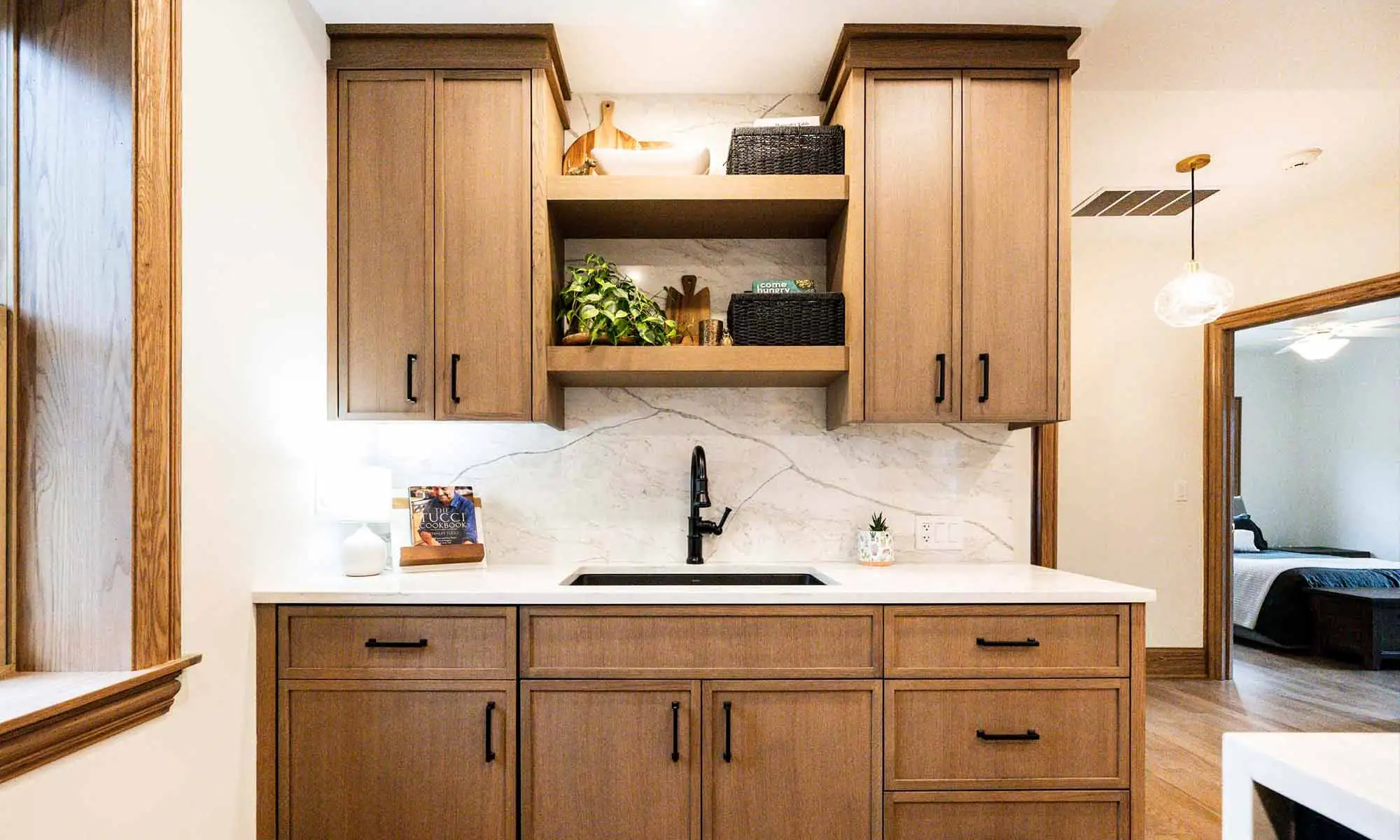 sink wall of luxury kitchen remodel with black faucet and white oak cabinetry