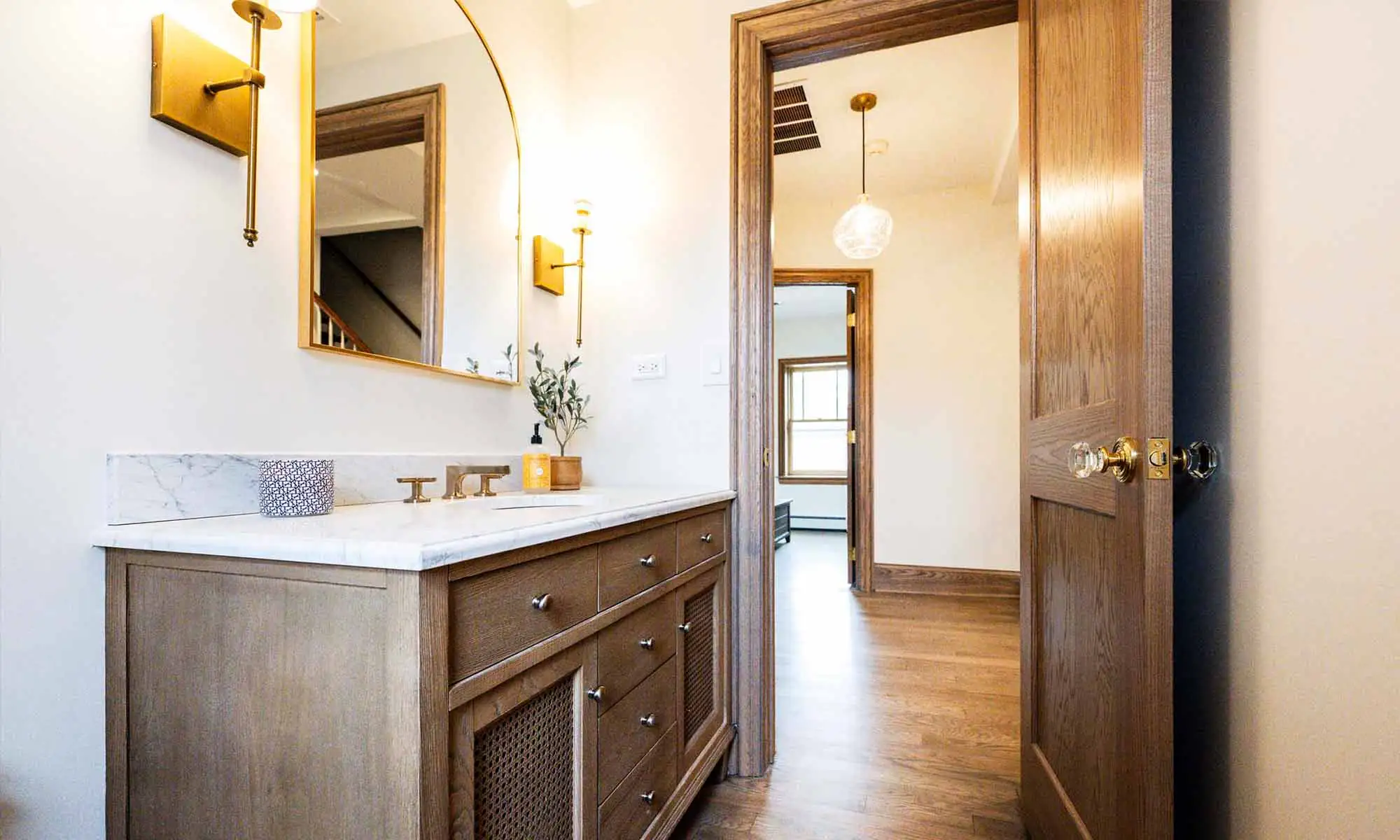 luxury powder room remodel with brass plumbing fixtures and mirror