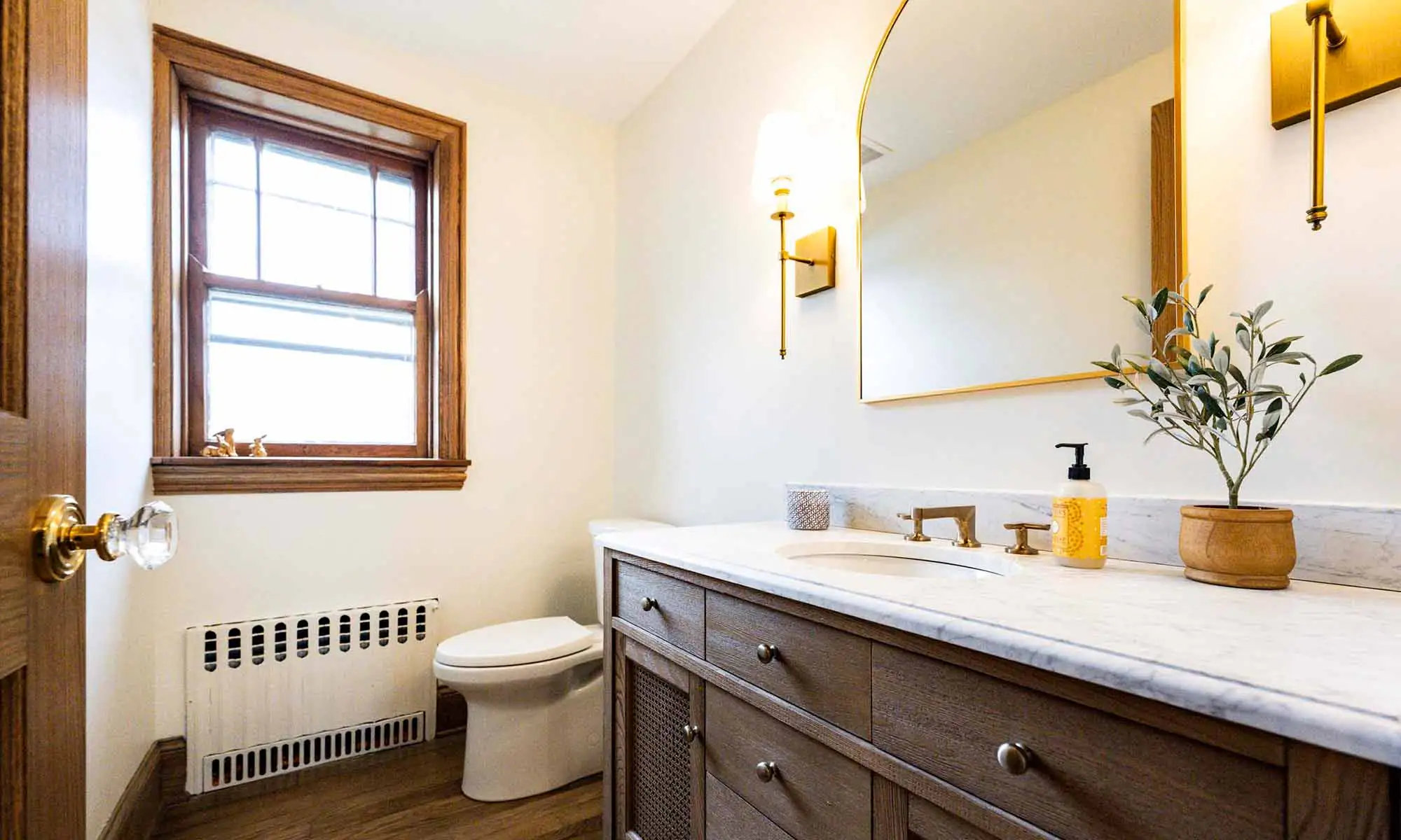 luxury powder room remodel with brass plumbing fixtures and mirror