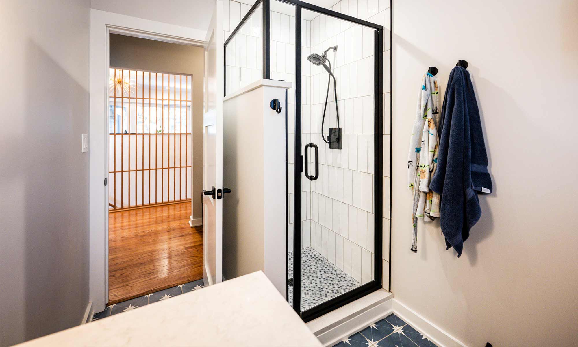 A bathroom featuring a shower and a blue tile floor, creating a serene and modern atmosphere.